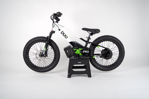 “DUO 20″ Podium Pro kids electric balance bike – side profile, black, on stand”