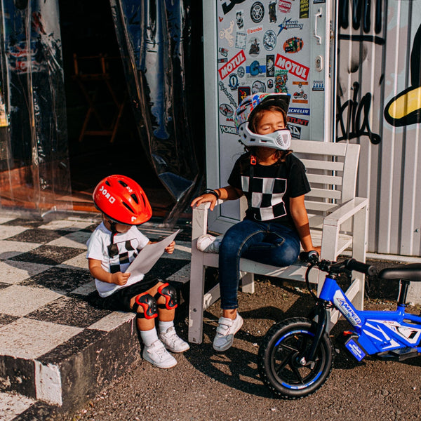 Amped kids electric balance bike with young riders wearing safety gear